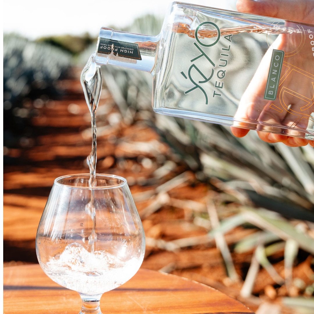Yéyo Tequila Blanco 96 High Proof being poured into a glass in the agave fields
