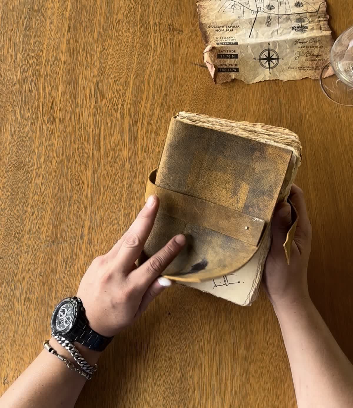 The worn leather-bound Yéyo book held open on a wooden table at the distillery