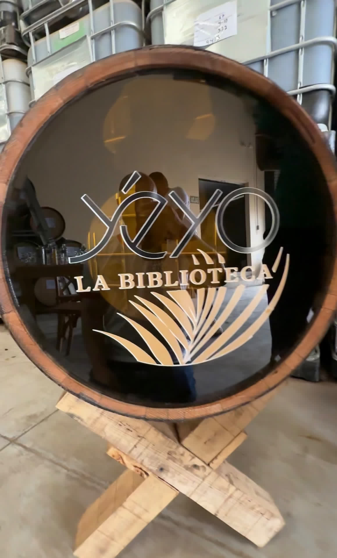 The glass head of the La Biblioteca barrel, etched with Yéyo La Biblioteca, on a wooden stand